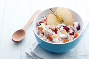 Healthy bowl of muesli, apple, fruit, nuts and milk for a nutritious breakfast with a low glycemic index ensuring plenty of energy for the day